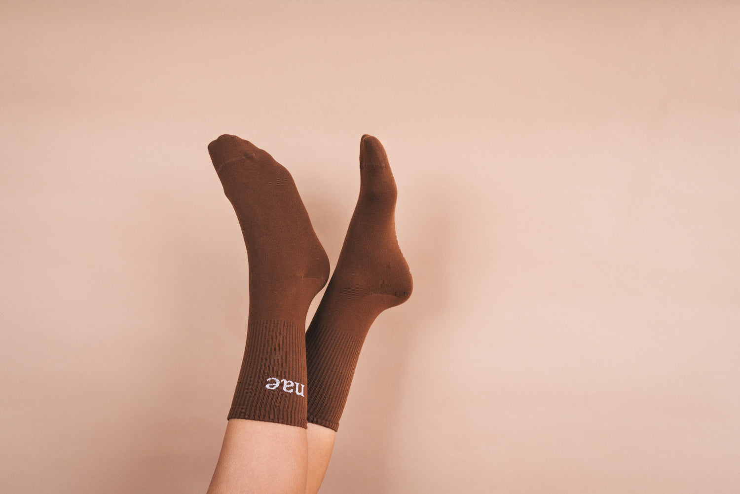 two feet wearing brown socks