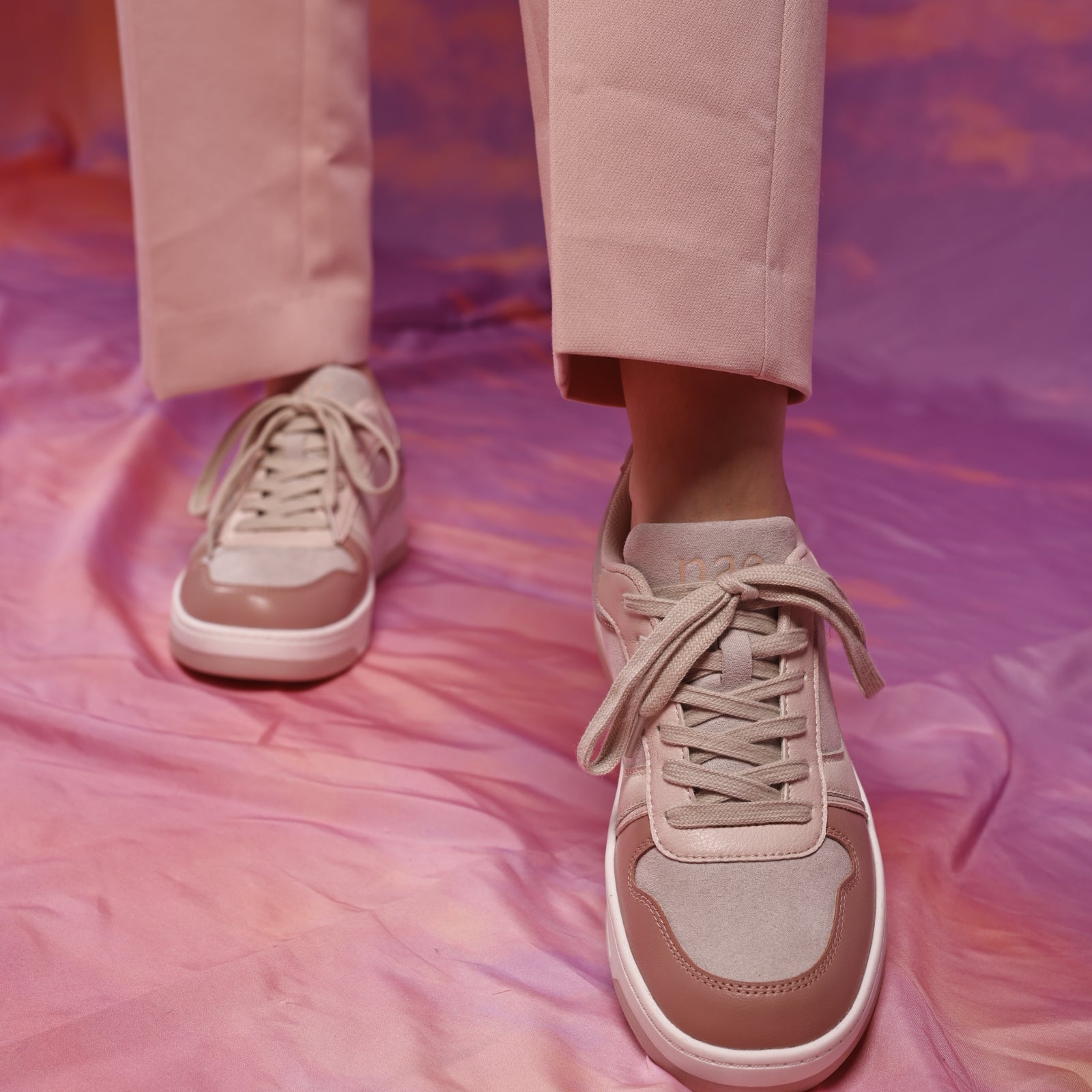 Women white and pink trainers wearing casual pants on cloud background | NAE Footwear