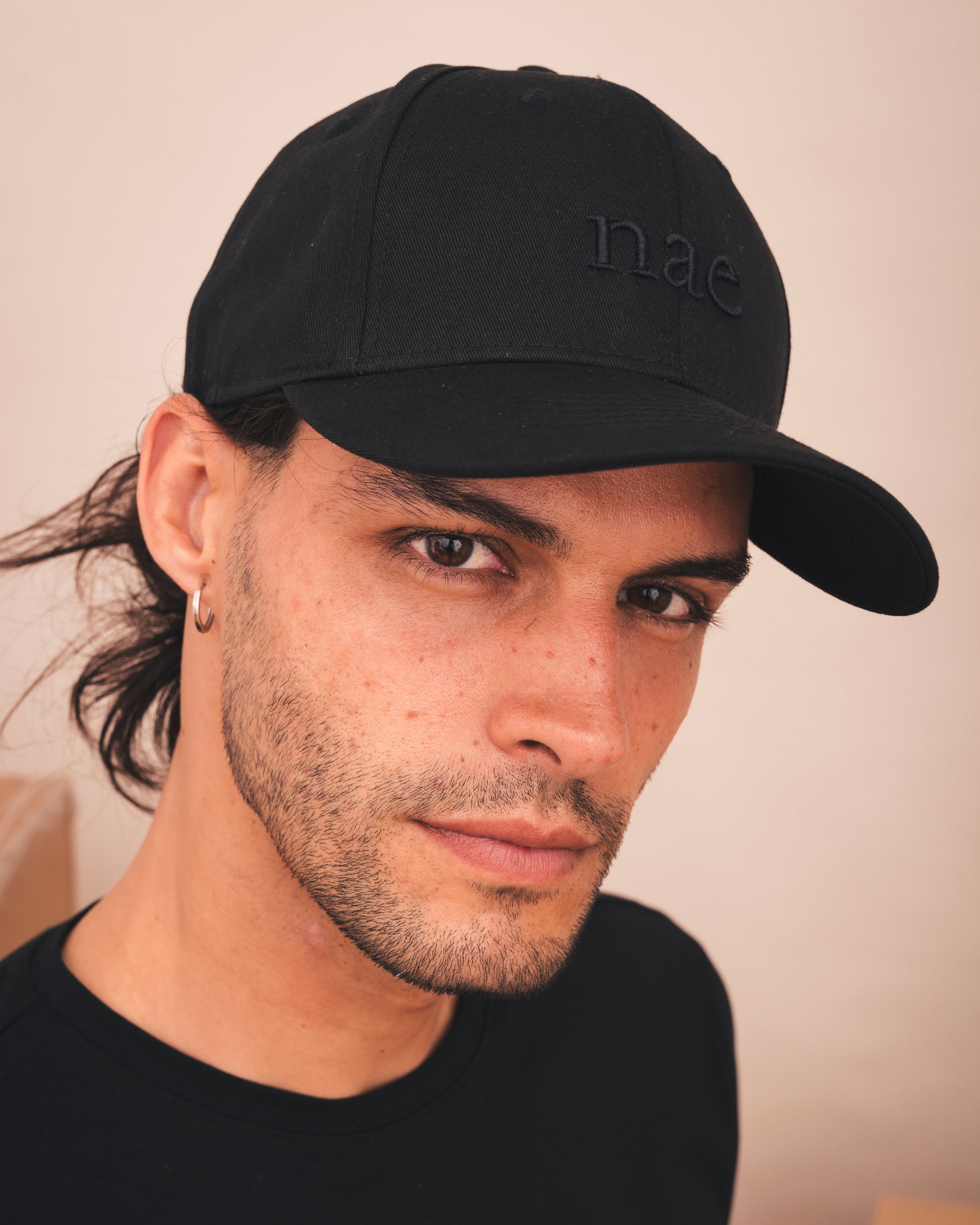 Man wearing a black cap with nae branding