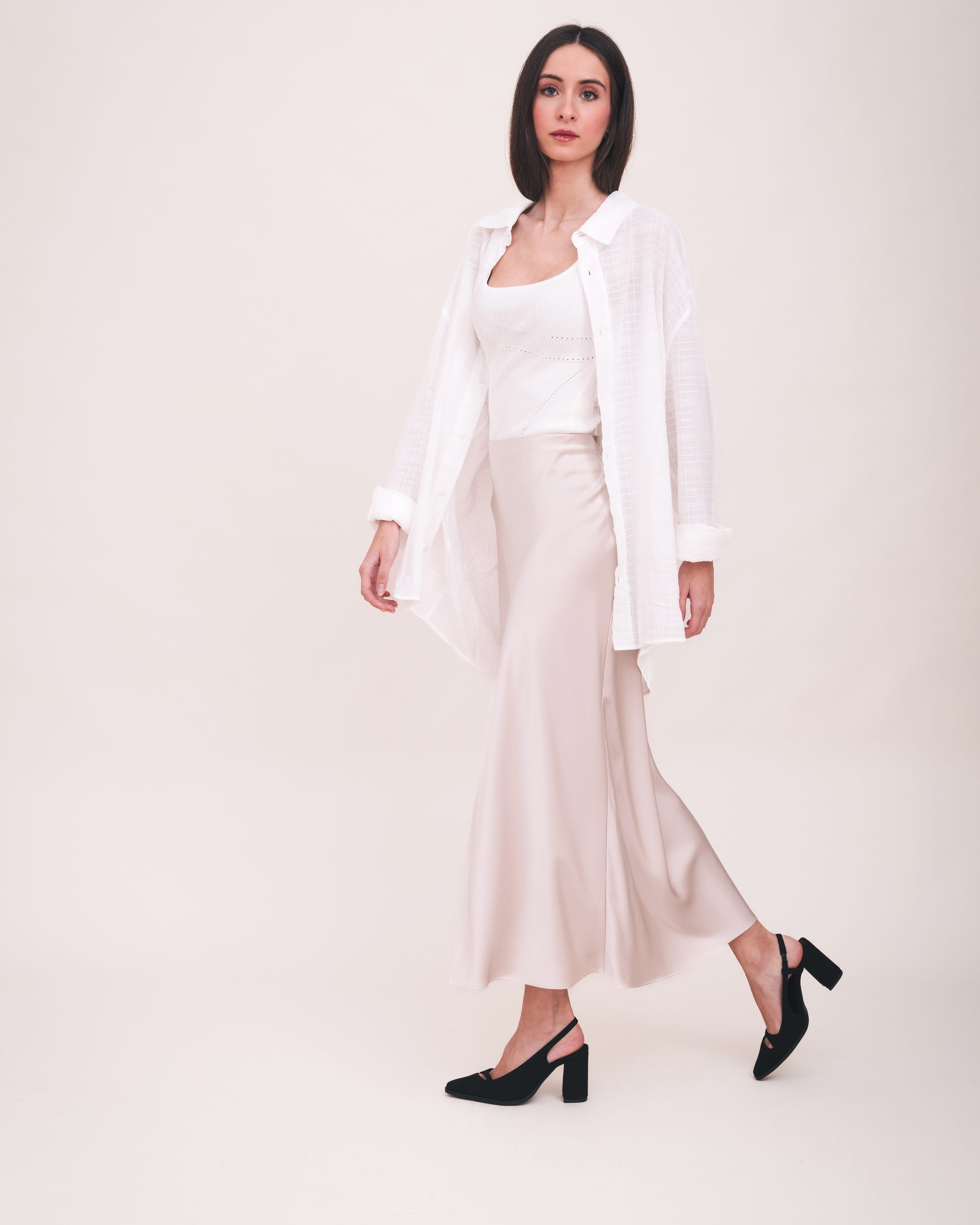 Woman wearing a white outfit with a plain background