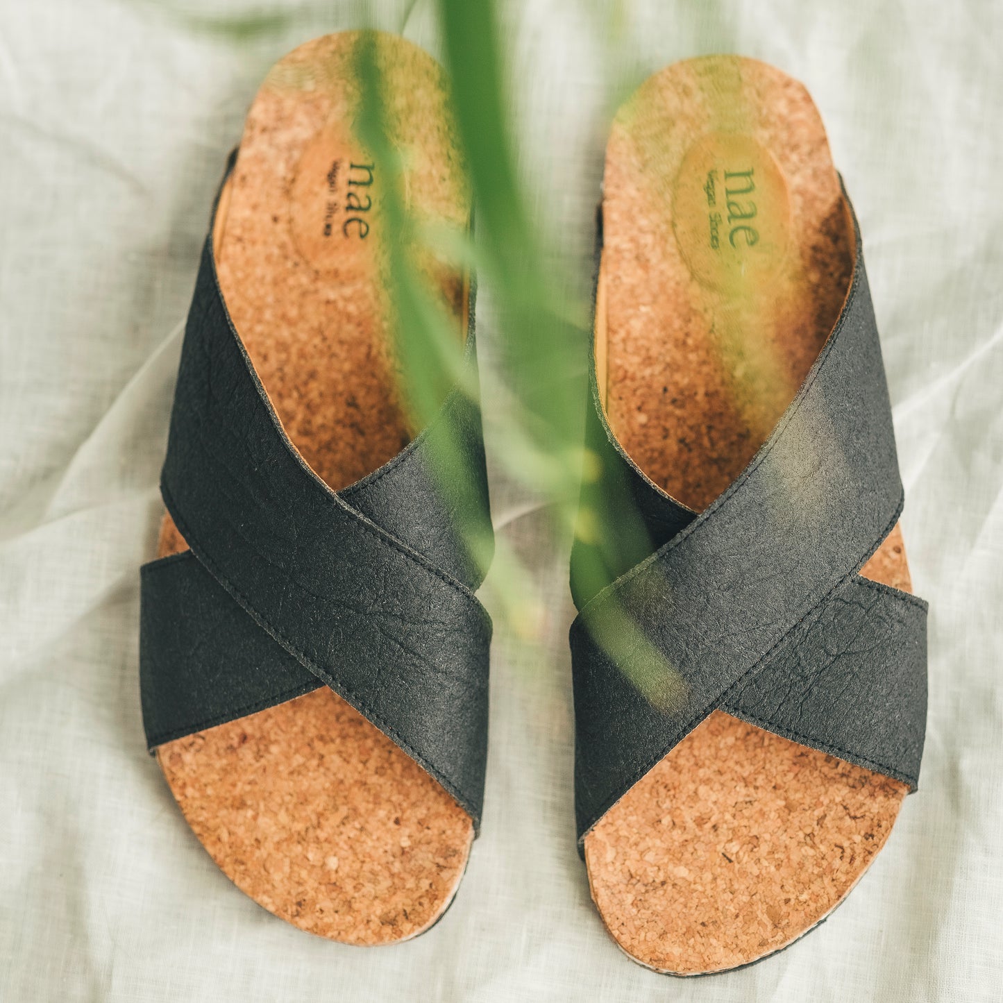 Two black vegan sandals upper view for women and men with logo on the insole | NAE Footwear