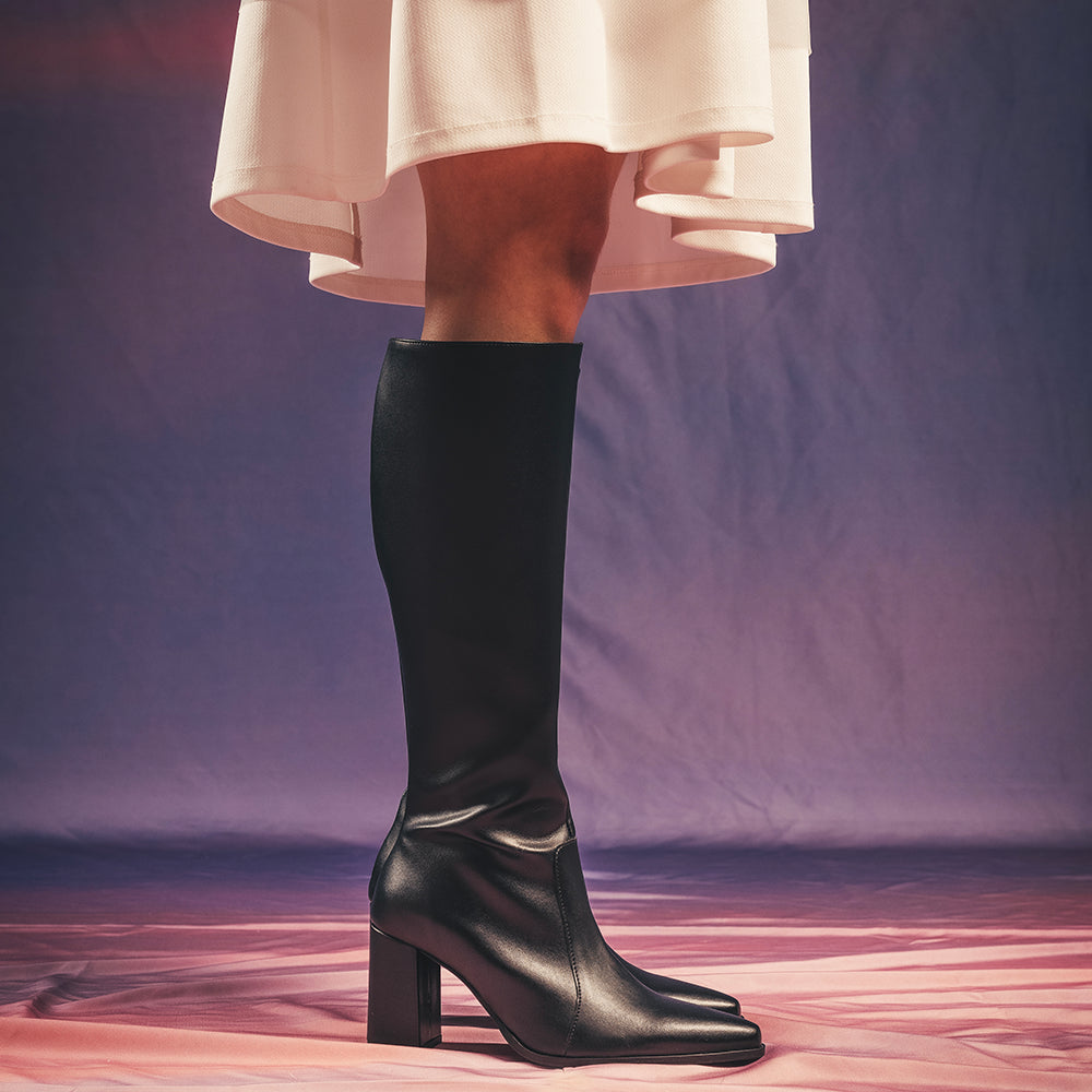 High boots for women wearing skirt on cloud background lifestyle | NAE Vegan Shoes