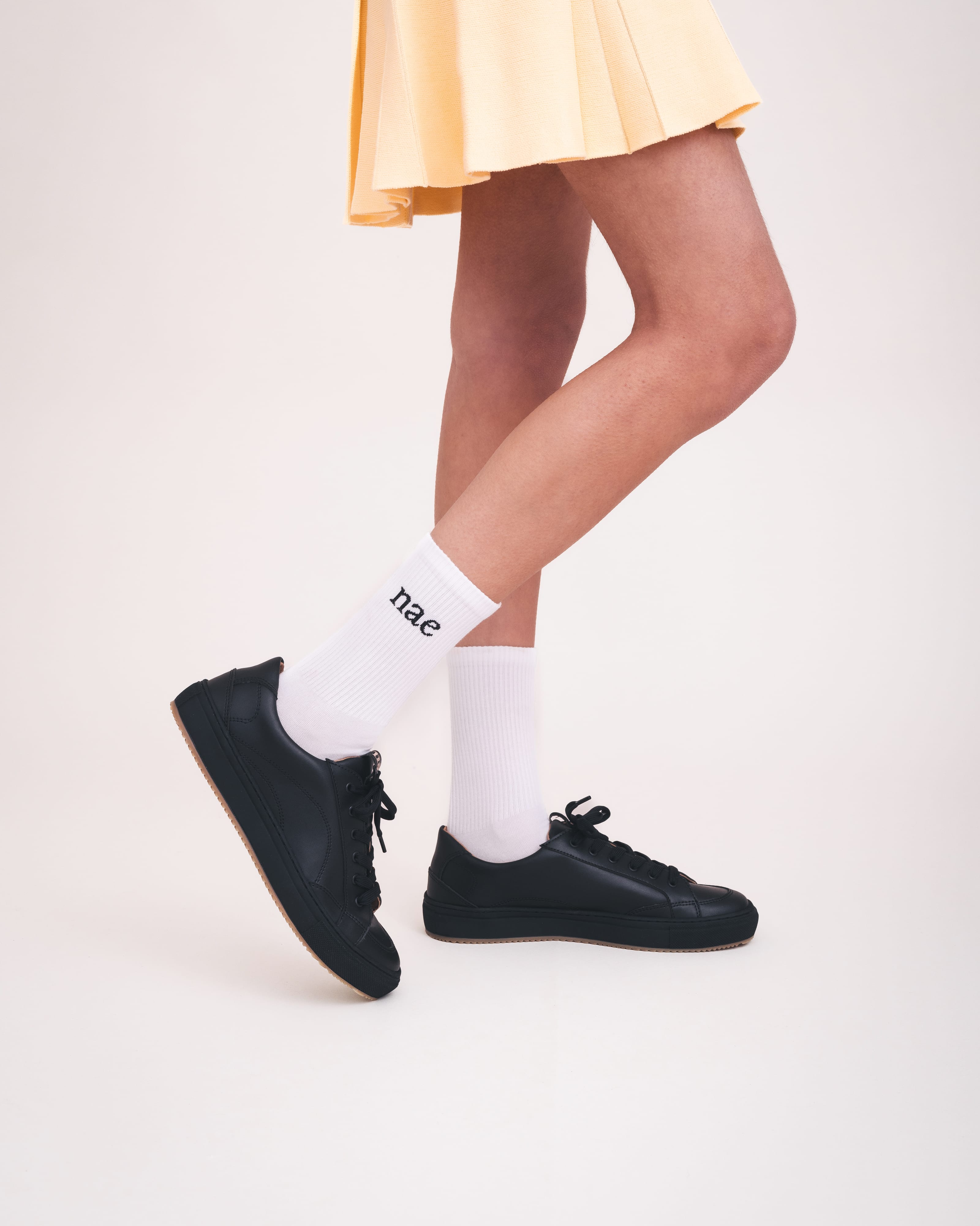 NAE Vegan Shoes black sneakers urban style low-top lace-up with skirt and socks