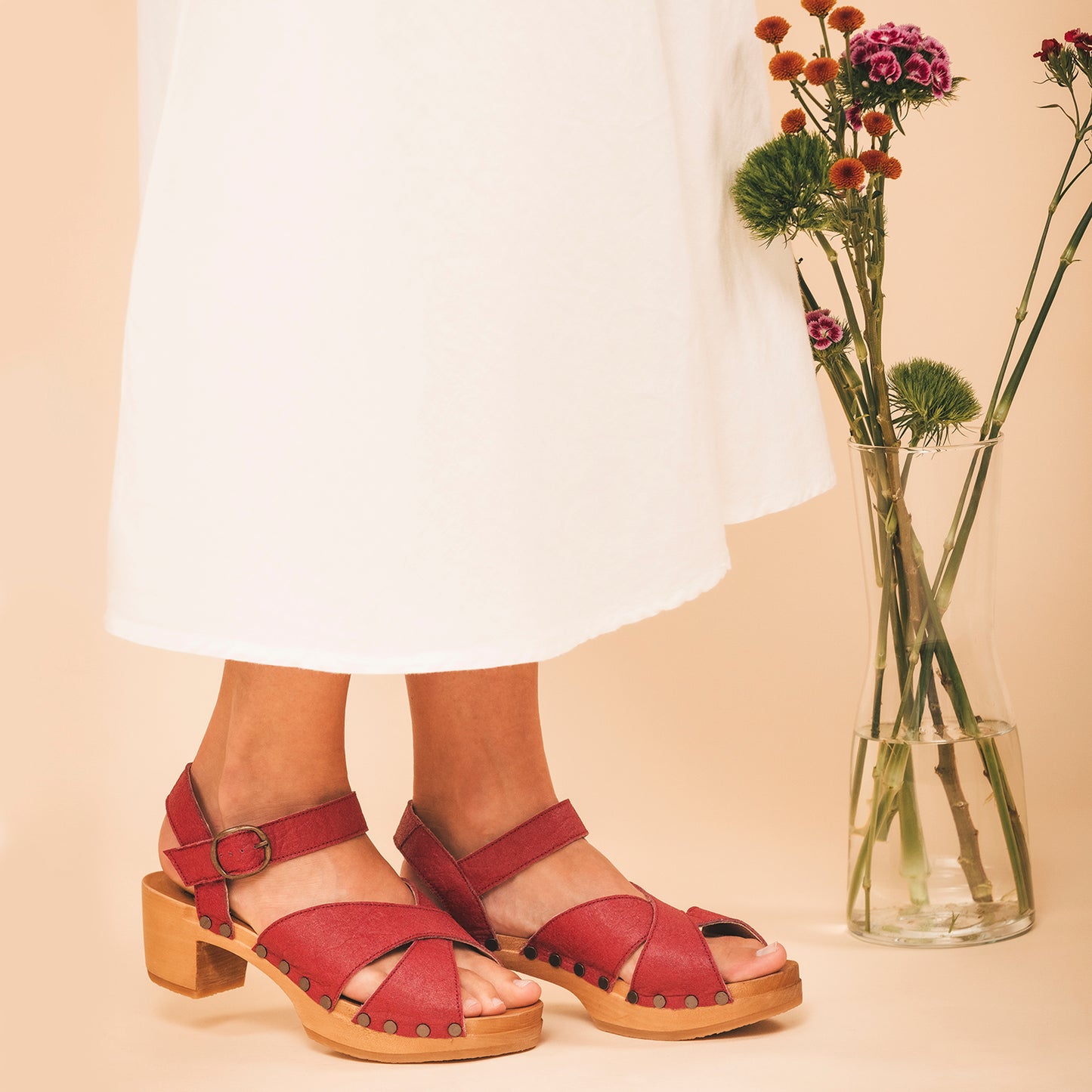 Red heels crafted from pineapple leaf fibers by-product fabric wearing white dress | NAE