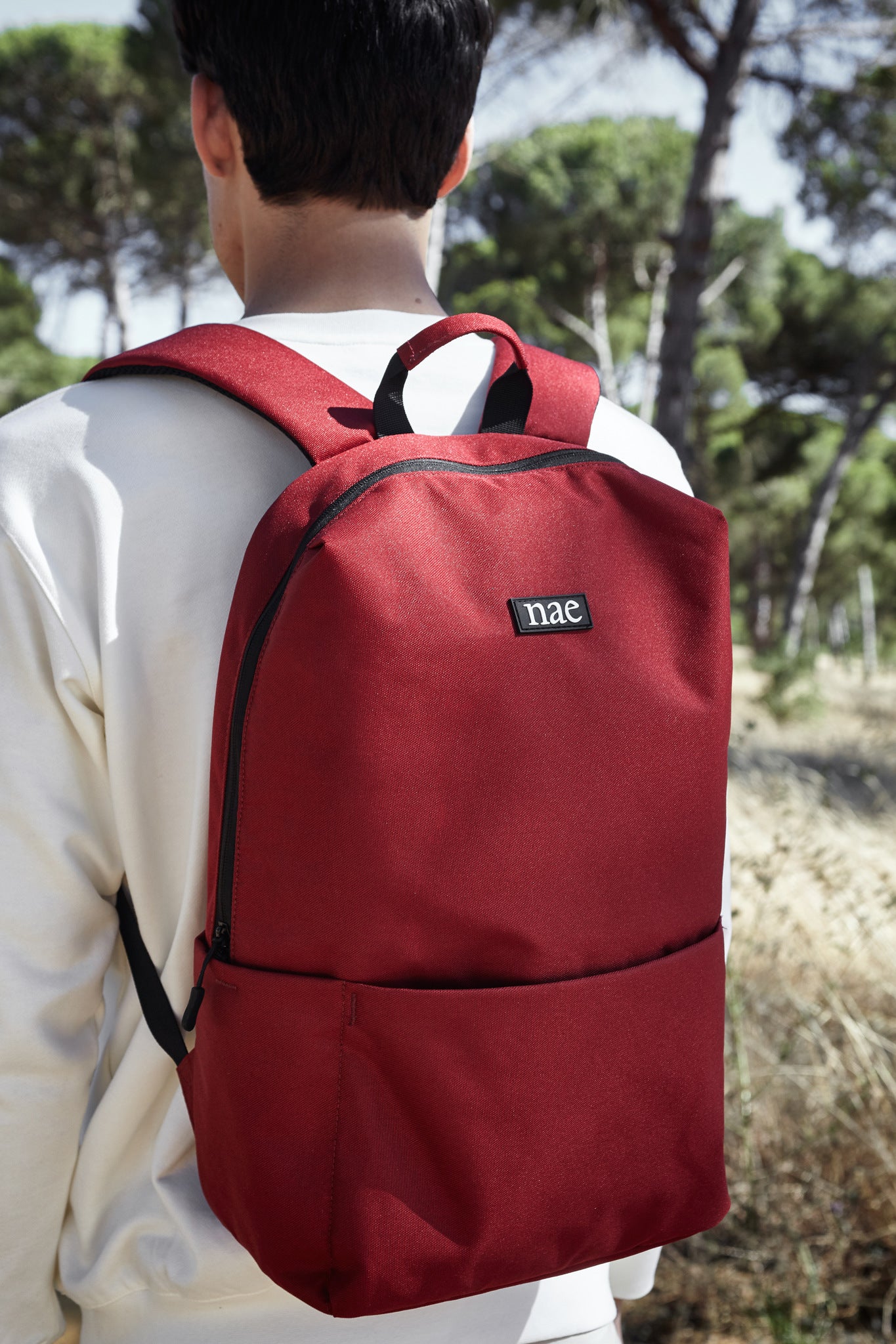 Men wearing a vegan bag with white clothes made with recycled sustainable NAE Materials