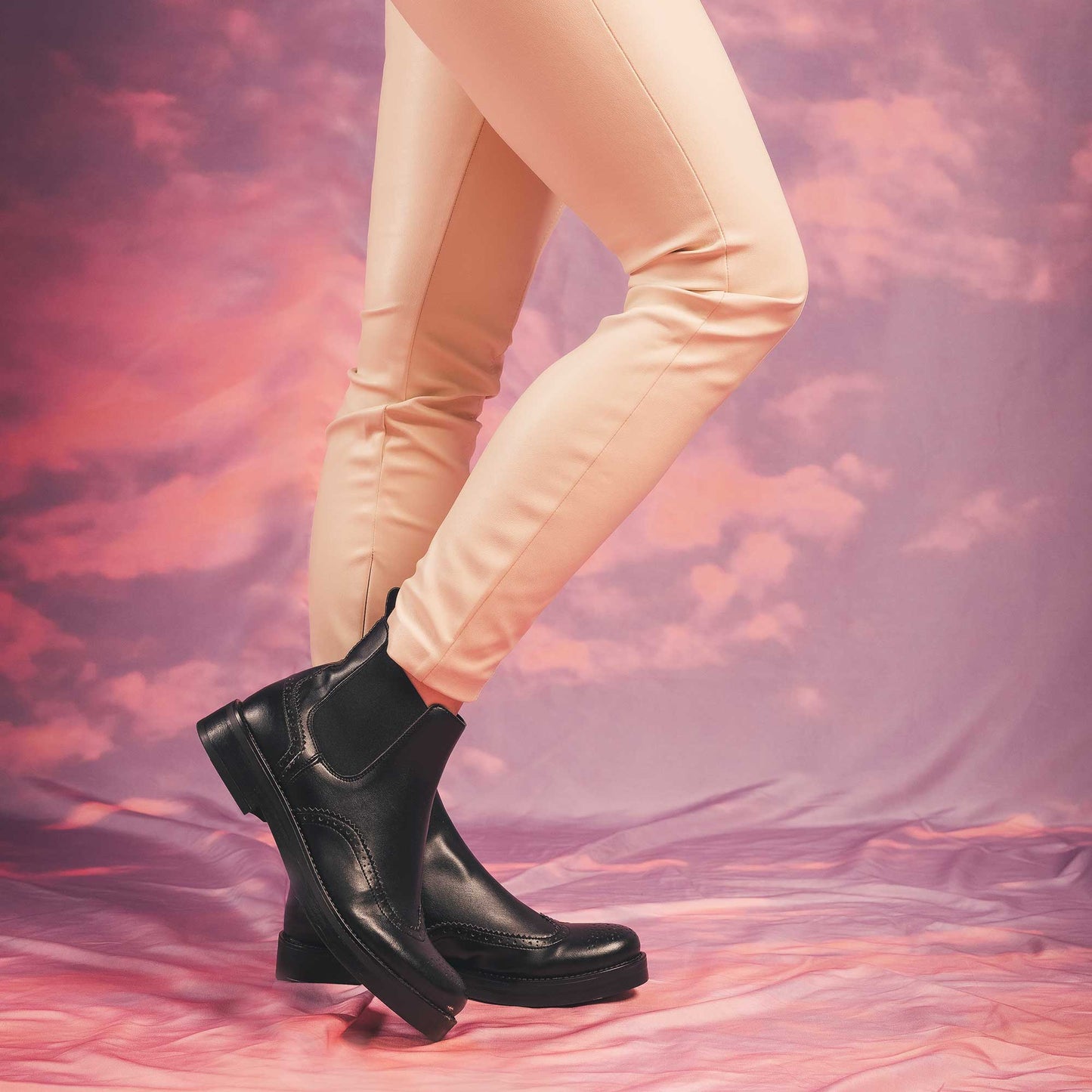 Women black chelsea boots wearing white pants with cloud background | NAE Vegan Shoes