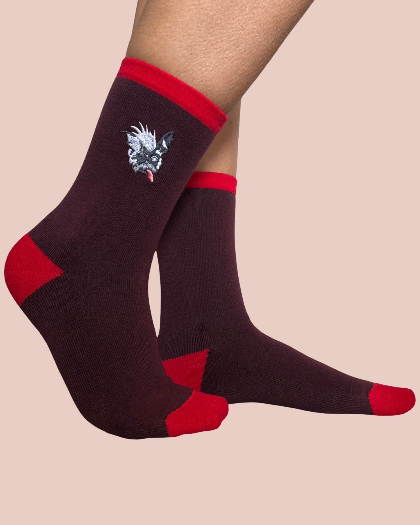 Dark brown socks with red accents and a unique design on a beige background