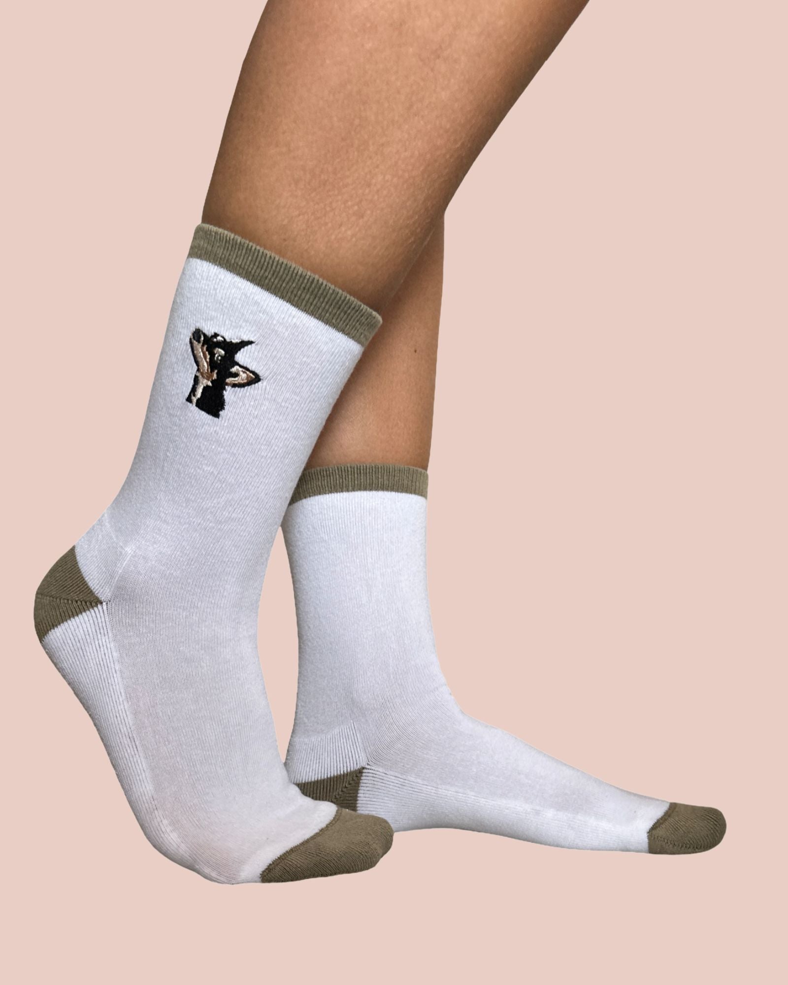 White socks with green accents worn by a person on a beige background